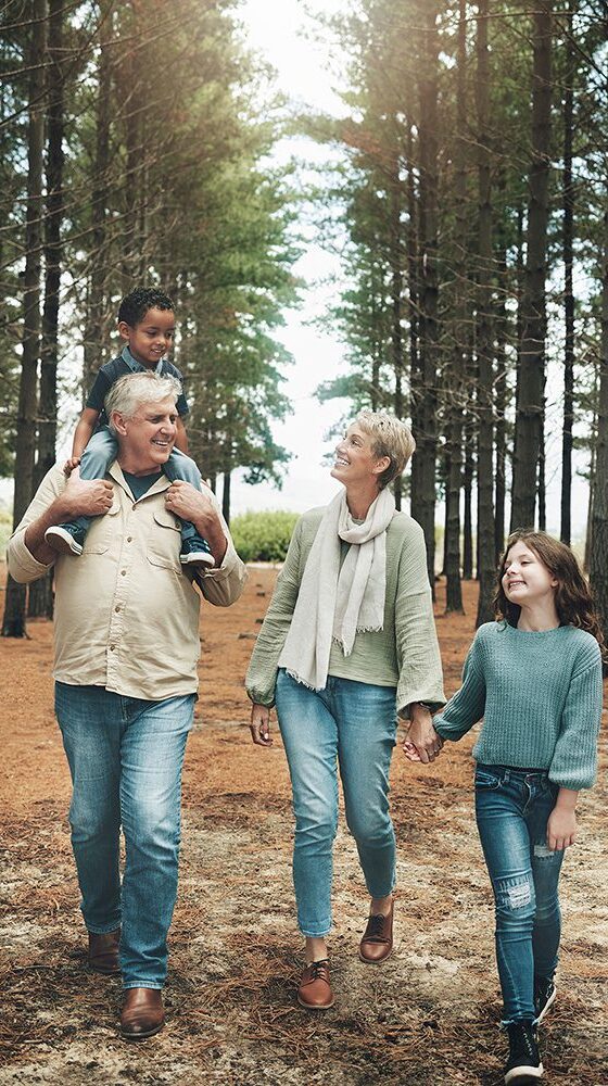 grandparents walking in the woods with their grandkids